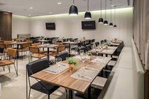 a restaurant with tables and chairs in a room at Intercity Pátio Pinda Hotel & Resort in Pindamonhangaba