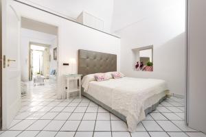 a white bedroom with a large bed and a mirror at Cartiera Apartment with Pool by AMALFIVACATION in Amalfi