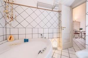 a bath tub in a bathroom with a white tiled wall at Cartiera Apartment with Pool by AMALFIVACATION in Amalfi +20 photos
