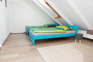 een slaapkamer met een blauw bed op een zolder bij Apartament Loft DeLuxe Koszalin in Koszalin