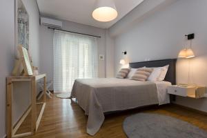 a white bedroom with a bed and a window at Absolute Athens I in Athens