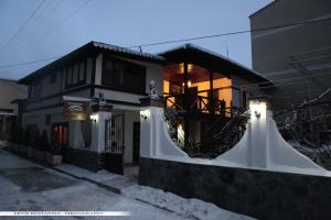 a house with a balcony with lights on it at Guest House Bujtina Leon in Korçë