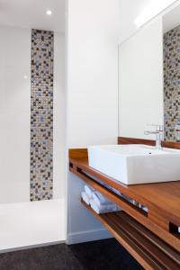 La salle de bains est pourvue d'un lavabo blanc sur un comptoir en bois. dans l'établissement Hotel du port, à Locquirec