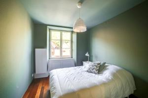 ein Schlafzimmer mit einem weißen Bett und einem Fenster in der Unterkunft Andlau, Cour de l'Abbaye in Andlau