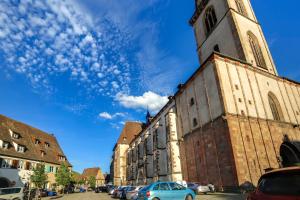 ein altes Gebäude mit einem Uhrturm auf einer Straße in der Unterkunft Andlau, Cour de l'Abbaye in Andlau