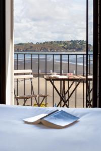 einen Tisch auf dem Balkon mit Blick auf den Strand in der Unterkunft Hotel du port in Locquirec