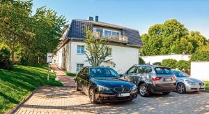 dos autos estacionados en un estacionamiento frente a una casa en Hotel zum Kuhhirten en Bremen