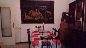 una sala da pranzo con tavolo e un dipinto sul muro di Casa Massimo a Moneglia