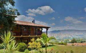een groot huis met een balkon op een tuin bij Hotel Spa Casa de Adobe Villa de Leyva in Villa de Leyva