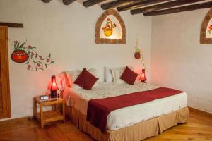 1 dormitorio con 1 cama con 2 lámparas en una mesa en Hotel Spa Casa de Adobe Villa de Leyva, en Villa de Leyva
