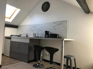 een keuken met een aanrecht en twee zwarte krukken bij Luxury Suite Lilas in Dijon +23 foto's