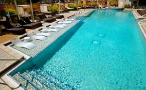 a large swimming pool with lounge chairs in a hotel at Hard Rock Hotel & Casino Tulsa in Tulsa