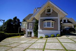 a house with a car parked in front of it at Vila de Charme Suítes in Campos do Jordão +127 photos