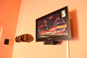 TV de pantalla plana colgada en la pared en Pasos Cortos Cabañas Nono en Nono