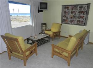 sala de estar con 2 sillas y TV en Mecohue en Playas Doradas