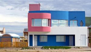 una casa azul y blanca con una valla en Mecohue en Playas Doradas