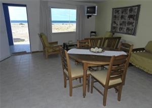 un comedor con mesa y sillas y la playa en Mecohue en Playas Doradas