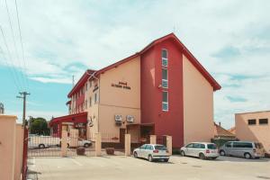 un edificio rosso con auto parcheggiate in un parcheggio di Penzion Hviezda a Bratislava