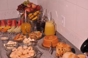a counter top with a bunch of food and drinks at Hotel Capim Dourado in Palmas