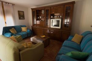 a living room with two couches and a tv at Casa Mili in Azucaica