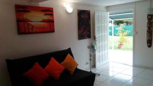 a living room with a couch and a painting on the wall at Rico in Saint-François
