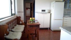 een keuken met een tafel met daarop een vaas met bloemen bij Logra-Sol in Figueira da Foz