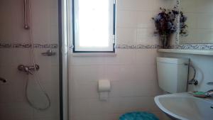 een badkamer met een douche, een toilet en een wastafel bij Logra-Sol in Figueira da Foz +15 foto's