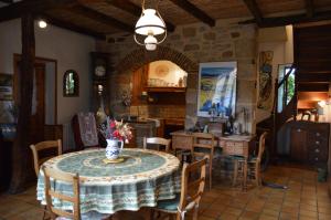 una cucina e una sala da pranzo con tavolo e sedie di Le Tilleul a Anglars