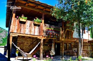 a wooden building with flower boxes on it at Kalinia Guesthouse B&B in Kovachevitsa