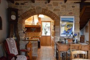 una cucina con arco, tavolo e orologio di Le Tilleul a Anglars