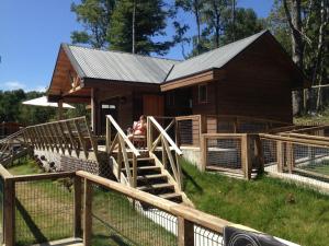 a barn with a girl sitting on the stairs in front of it at Departamento Pucon in Pucón