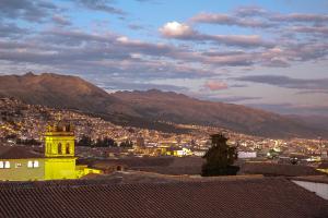 una ciudad con una torre de reloj con montañas en el fondo en Hotel Elmer-Z, en Cusco