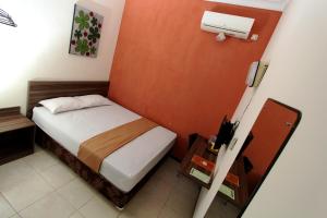 a small bedroom with a bed in a room at Guest House Rumah Wahidin Syariah in Probolinggo
