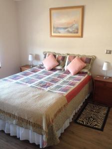 Un dormitorio con una cama con almohadas rosas. en Departamento a pasos del centro de Viña y terminal, en Viña del Mar