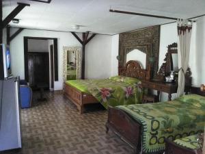 a bedroom with two beds and a tv in it at Gazebo Beach Hotel in Sanur +99 photos