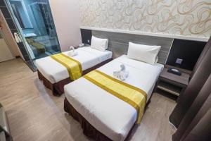 Postel nebo postele na pokoji v ubytování Indra Hotel Ipoh