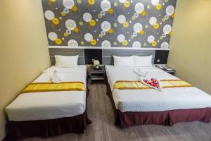 Postel nebo postele na pokoji v ubytování Indra Hotel Ipoh