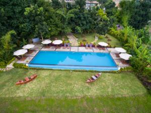 an overhead view of a swimming pool with chairs and umbrellas at Amata Garden Resort, Inle Lake in Ywama