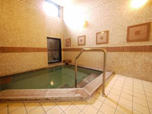 una gran piscina de agua en el baño con bañera en Hotel Route-Inn Isahaya Inter, en Isahaya