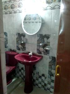 a bathroom with a red sink and a mirror at Osheen Family Guest House in Polonnaruwa