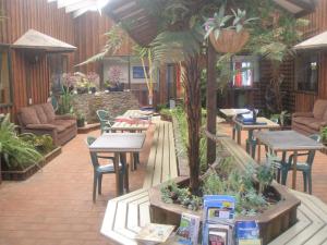 a garden area with tables, chairs, and tables at Wilderness Backpackers in Haast