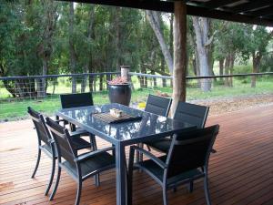 einen Esstisch und Stühle auf einer Terrasse in der Unterkunft Silversprings cottages in Metricup