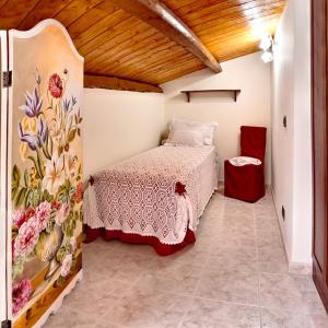 - une chambre avec un lit orné d'une fresque murale représentant des fleurs dans l'établissement B&B Myosotis, à Introdacqua