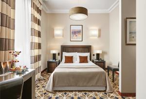 a hotel room with a bed and a desk at Hôtel Juana in Juan-les-Pins