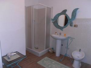 La salle de bains est pourvue d'un lavabo, d'une douche et de toilettes. dans l'établissement La Dea Madre, à Stintino