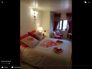 - une chambre avec un grand lit et des oreillers rouges dans l'établissement La Ferme de Là-haut B&B, à Le Haut-du-Them