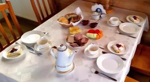 un tavolo con tazze e piatti di cibo sopra di Wiśniowy Sad a Białowieża