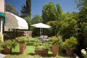 a patio with an umbrella and chairs and plants at Hotel Palace del Conero in Osimo