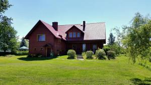 una grande casa con un ampio cortile con erba verde di Wiśniowy Sad a Białowieża Altre 35 foto