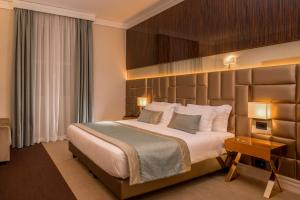 sypialnia z dużym łóżkiem z dużym zagłówkiem w obiekcie Hotel Gioberti w Rzymie